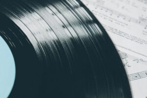 Vinyl record laying on top of sheet music from a movie score.