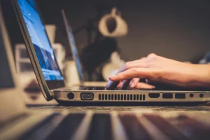 close up of a person's hands typing on a latop coomputer